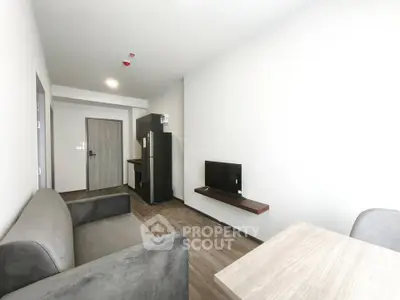 Modern minimalist living room with sleek furniture and open kitchen layout in a contemporary apartment.