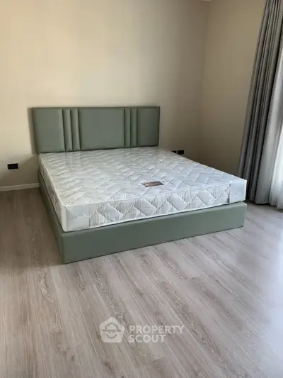 Modern bedroom with stylish green bed frame and natural light