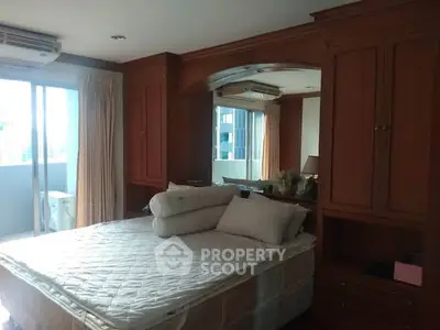 Spacious bedroom with wooden built-in wardrobe and balcony access