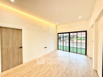 Spacious modern living room with large windows and wooden flooring