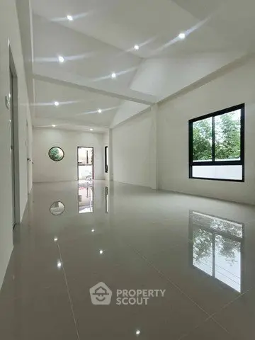 Spacious modern interior with glossy tiled floors and large windows.