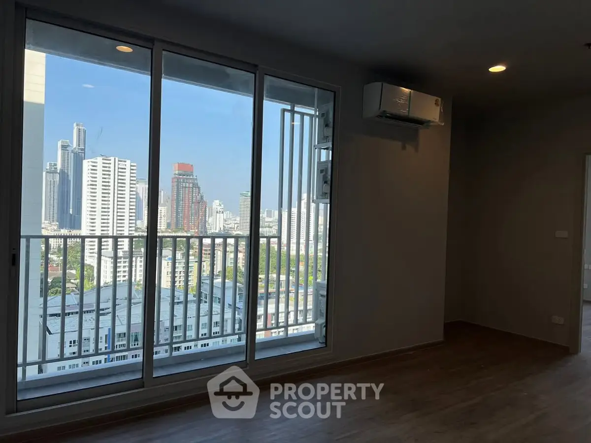 Modern apartment with city view and large windows, featuring sleek flooring and air conditioning.