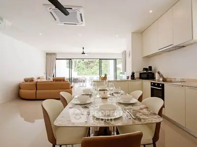 Spacious open-plan living and dining area with modern kitchen and elegant decor.