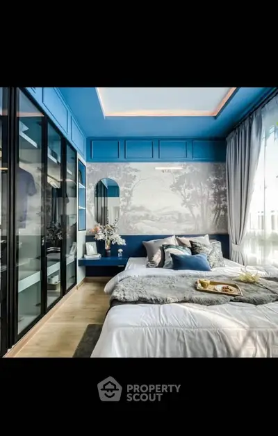 Luxurious bedroom with elegant blue accents and large windows for natural light.