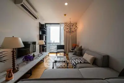 Modern living room with elegant chandelier and city view balcony, featuring stylish furniture and decor.
