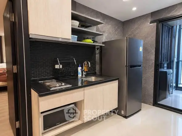 Modern kitchen with sleek appliances and open layout in stylish apartment.