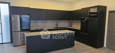 Modern kitchen with sleek black cabinets and built-in appliances