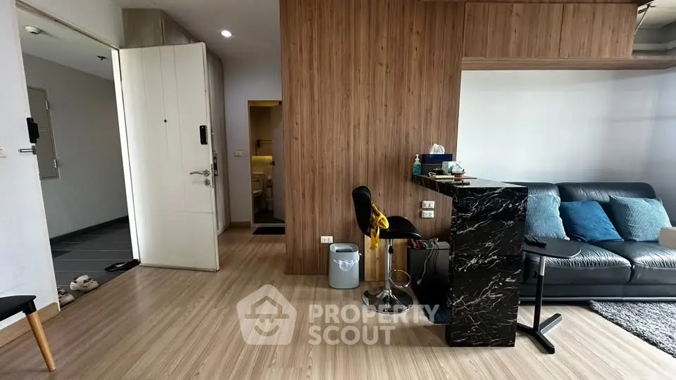 Modern living room with stylish decor and open layout, featuring a cozy sofa and sleek bar counter.