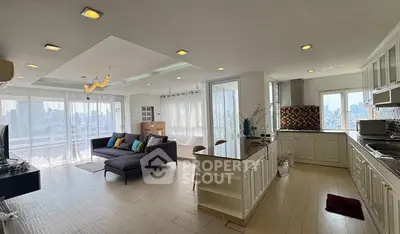 Spacious open-plan living room and kitchen with city view, modern design and ample natural light.
