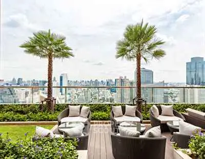 Luxurious rooftop terrace with stunning city skyline view and elegant seating area.