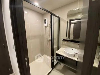 Modern bathroom with sleek shower and stylish vanity in contemporary apartment.