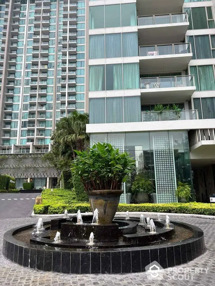 Modern high-rise building with elegant entrance and water fountain feature