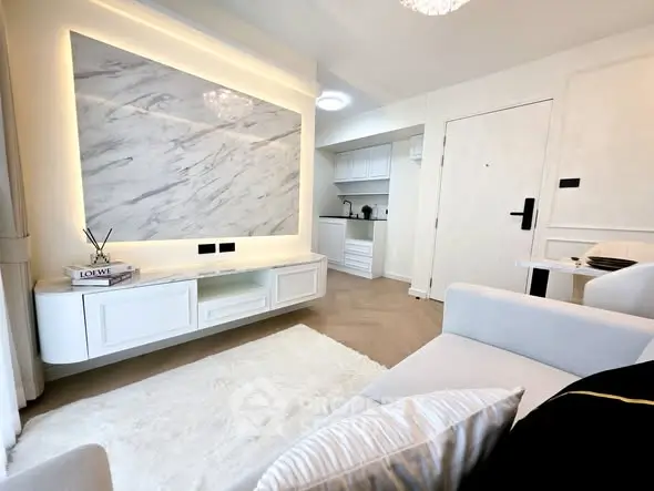 Modern living room with elegant marble accent wall and cozy white sofa.