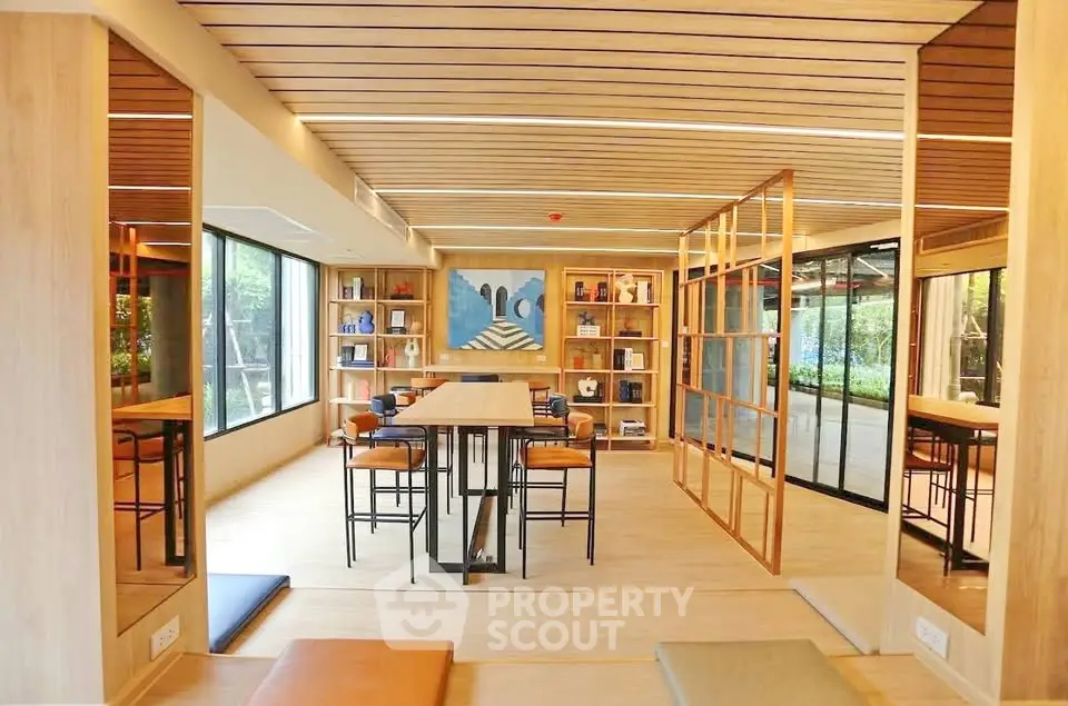 Modern co-working space with wooden accents and large windows offering a serene garden view.