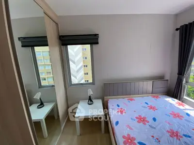 Cozy bedroom with floral bedding and mirrored wardrobe in modern apartment