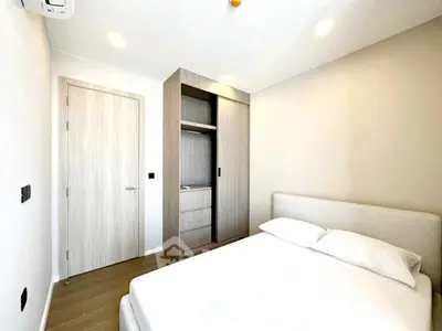 Modern minimalist bedroom with wooden wardrobe and cozy bed