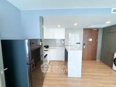 Modern kitchen with sleek appliances and wooden flooring in a stylish apartment