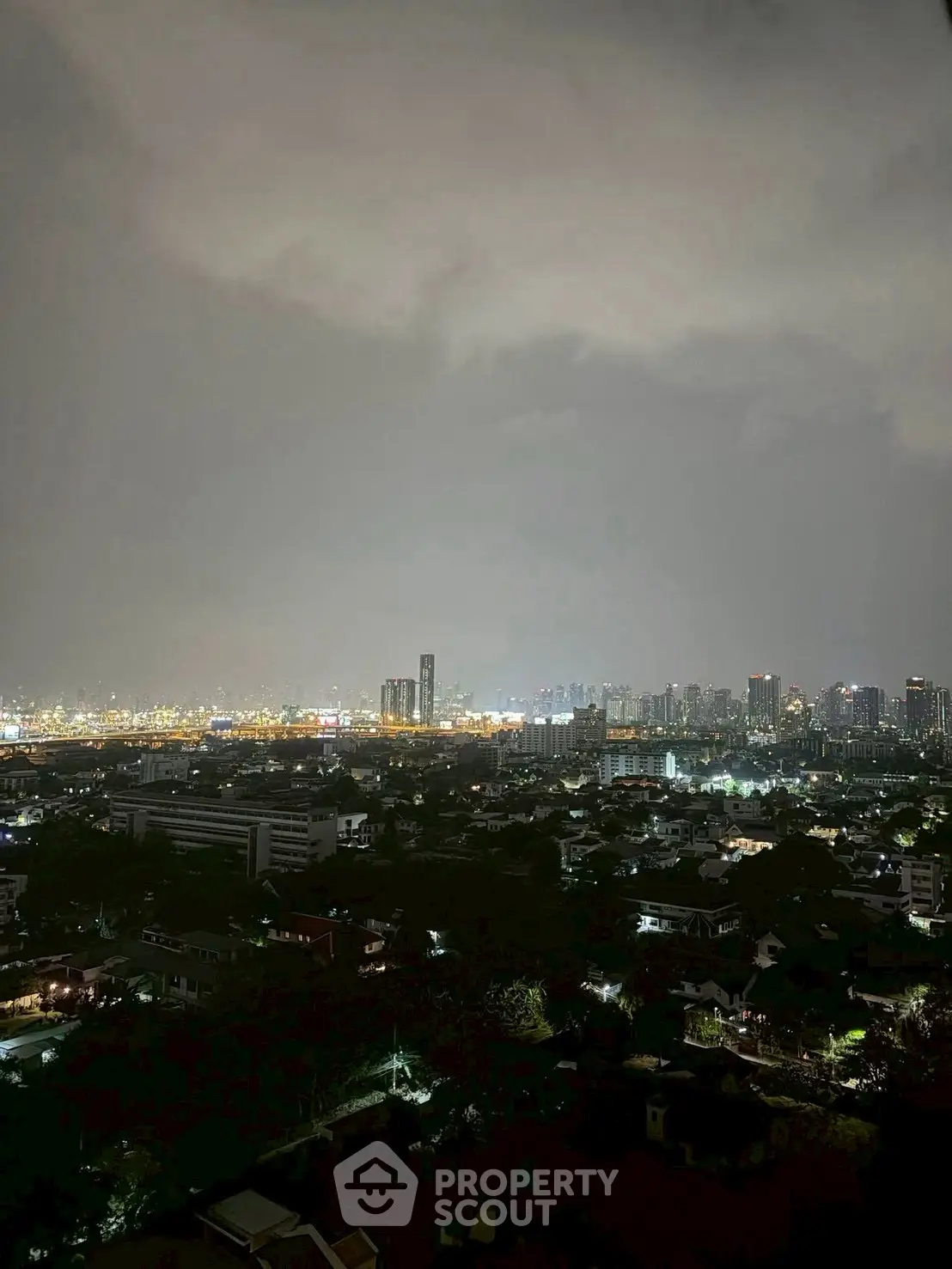 Stunning cityscape view from high-rise apartment showcasing vibrant urban skyline at night.