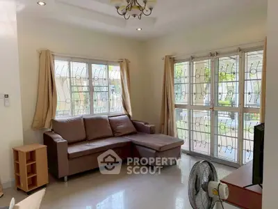 Spacious living room with large windows and cozy sectional sofa, perfect for relaxation and natural light.