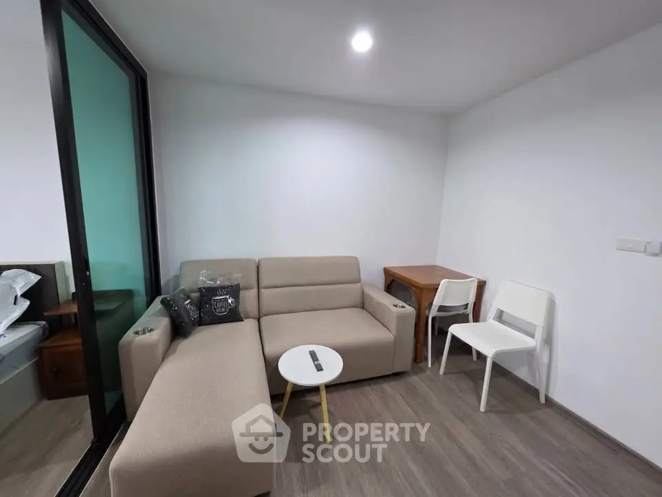 Cozy living room with modern beige sofa and small dining area