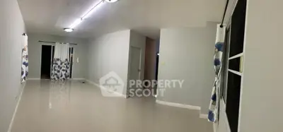 Spacious empty living room with modern lighting and large windows.