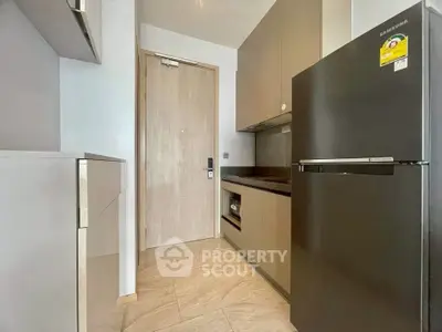 Modern kitchen with sleek appliances and minimalist design in a compact space.
