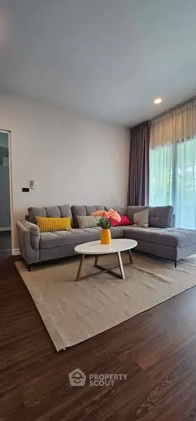Stylish living room with modern gray sectional sofa and bright decor accents.