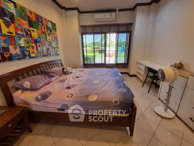 Spacious bedroom with modern art and large window view