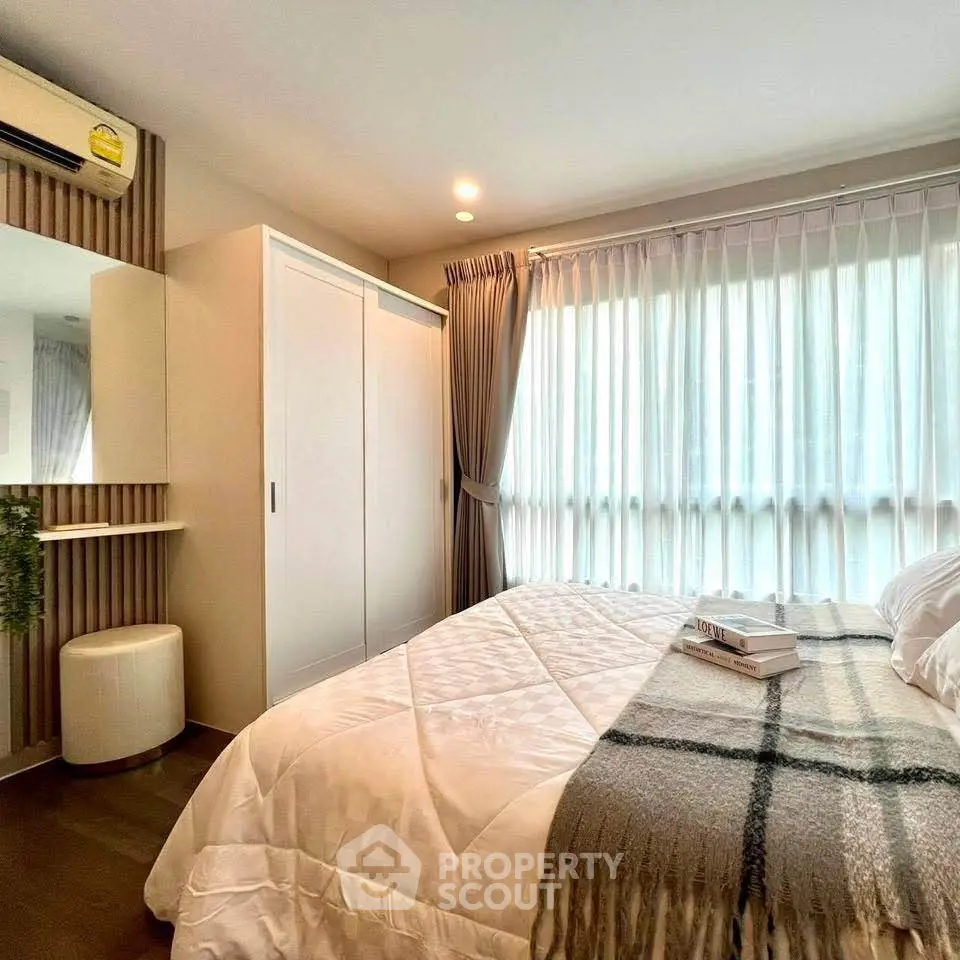 Cozy bedroom with large window and modern decor, perfect for relaxation and comfort.