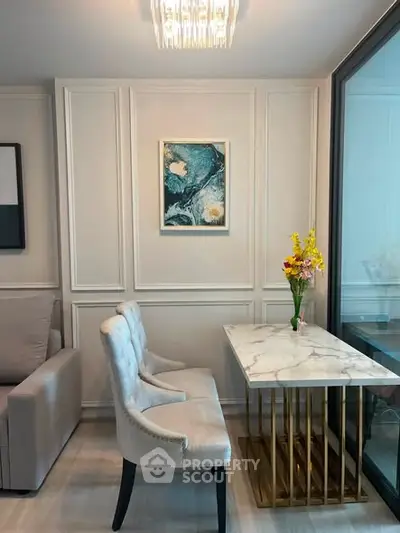 Elegant living room corner with marble table and plush chairs, perfect for modern interiors.