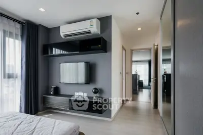 Modern bedroom with sleek design, featuring wall-mounted TV and air conditioning, perfect for urban living.