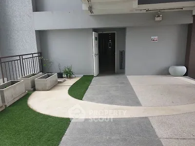 Modern apartment building entrance with stylish walkway and planters.
