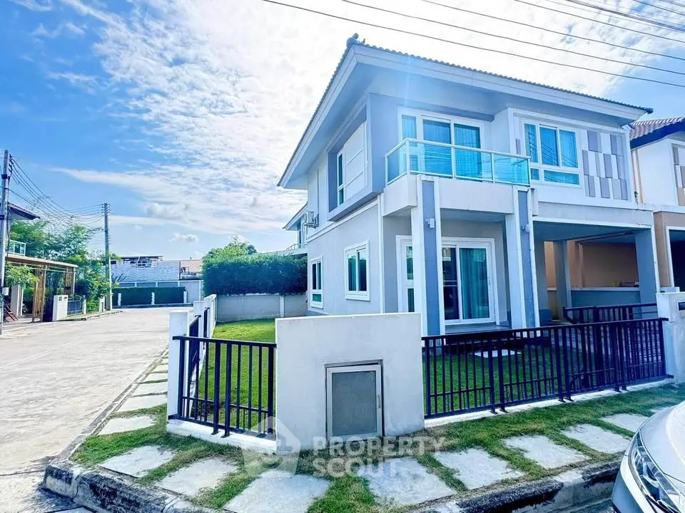 Modern two-story house with spacious yard and balcony in a serene neighborhood.