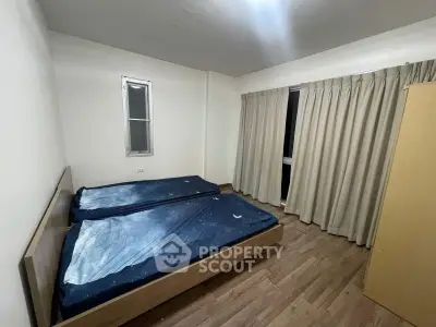Spacious bedroom with twin beds and large window in modern apartment