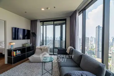 Modern living room with panoramic city views and stylish furnishings in a high-rise apartment.