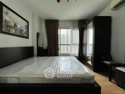 Spacious bedroom with modern furnishings and large window offering city views.
