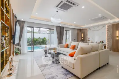 Luxurious living room with pool view, modern decor, and spacious seating area.