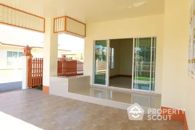 Spacious covered patio with sliding glass doors and tiled flooring