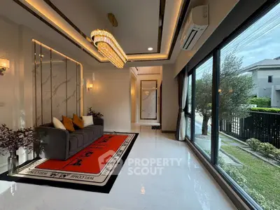 Luxurious living room with elegant chandelier and large windows offering garden view