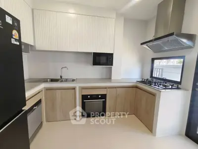 Modern kitchen with sleek cabinetry, built-in oven, and gas stove in a contemporary home.