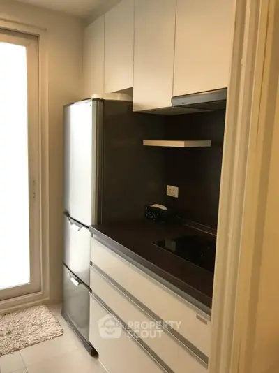 Modern kitchen with sleek cabinetry and built-in appliances in compact layout