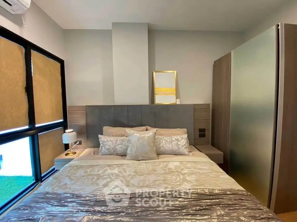 Modern bedroom with elegant decor and large window for natural light.