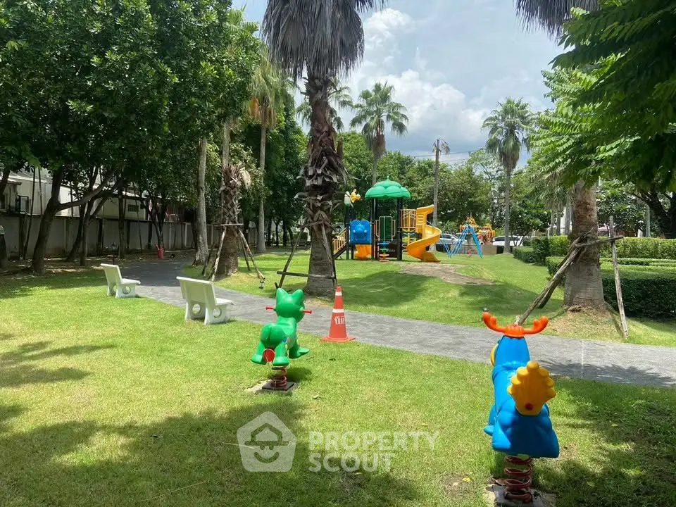 Charming residential playground with lush greenery and colorful play equipment, perfect for family-friendly living.