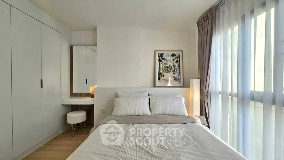 Modern bedroom with large window and stylish decor in a contemporary apartment.