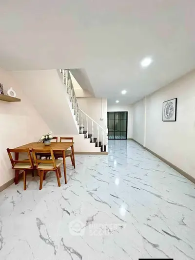 Spacious modern living area with elegant staircase and marble flooring