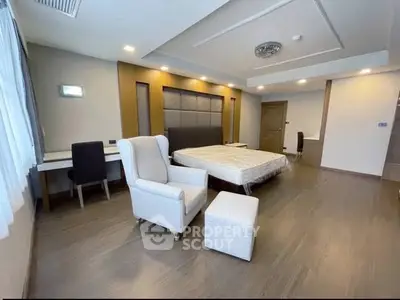 Spacious modern bedroom with elegant decor and ample natural light.