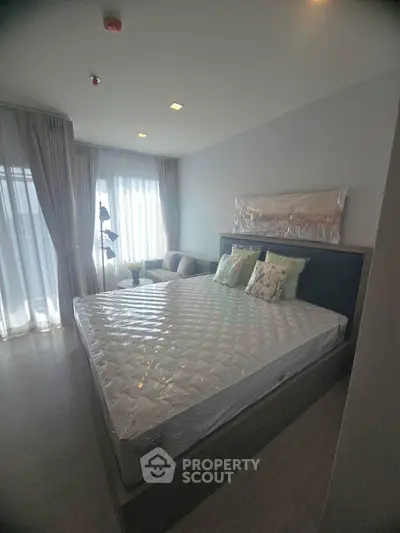 Modern bedroom with large windows and stylish decor in a contemporary apartment.