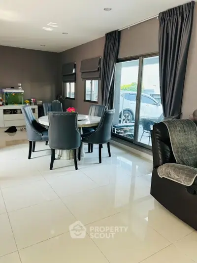 Spacious modern living room with elegant dining area and large windows for natural light.