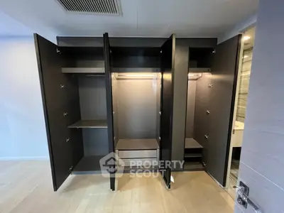Spacious modern wardrobe with open doors showcasing ample storage space and sleek design.