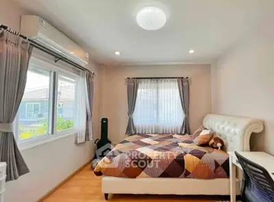 Cozy bedroom with stylish decor and ample natural light, perfect for relaxation and comfort.